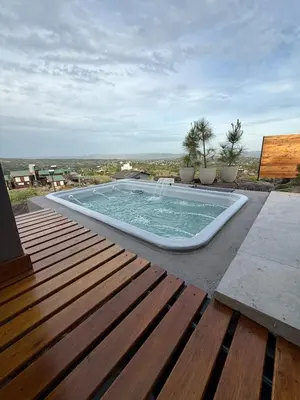 a large swimming pool on a patio with a wooden deck at MontSelah Casa en la montaña con pileta para 2 in Tanti