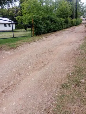 a dirt road with a fence and a house at Casa Los Hornillos in Los Hornillos