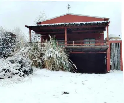 a house with snow on the ground in front of it at Los Fuegos in El Durazno