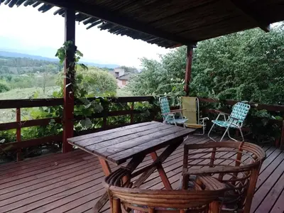 a wooden table and chairs on a wooden deck at Los Fuegos in El Durazno