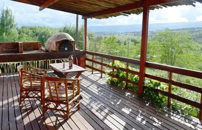 a wooden deck with a table and chairs and an outdoor oven at Los Fuegos in El Durazno
