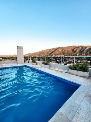 a blue swimming pool with a view of the desert at Dpto Carlos Paz - 1 dormitorio con pileta in Villa Carlos Paz