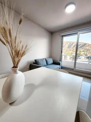 a white vase sitting on a table in a room at Dpto Carlos Paz - 1 dormitorio con pileta in Villa Carlos Paz