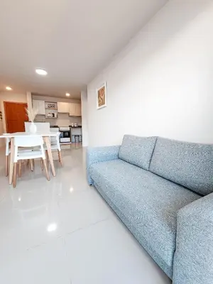 a living room with a blue couch and a table at Dpto Carlos Paz - 1 dormitorio con pileta in Villa Carlos Paz