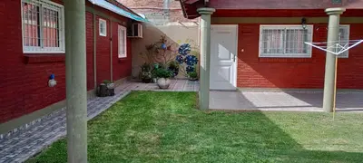 a red house with a basketball hoop in the yard at Cabañas LAS AMELIAS in Villa Cura Brochero