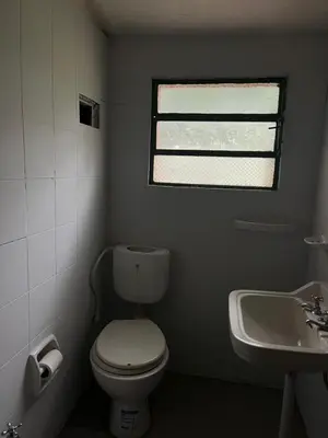a bathroom with a toilet and a sink and a window at Kasananda in Villa del Dique