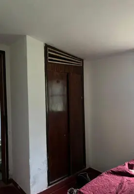a bedroom with a wooden door in the corner at Kasananda in Villa del Dique