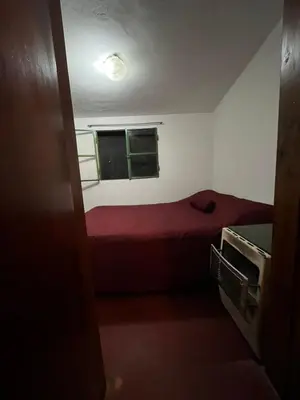 a small bedroom with a red bed and a window at Kasananda in Villa del Dique