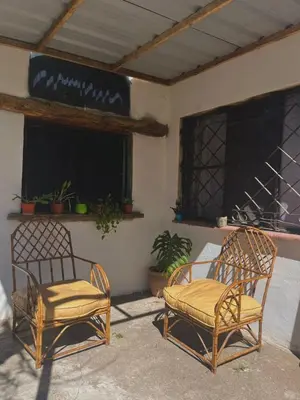 two chairs sitting in front of a building at Kasananda in Villa del Dique