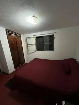a bedroom with a red bed and two windows at Kasananda in Villa del Dique