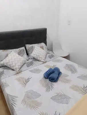 a bed with two blue mitts on top of it at Monoambiente Cerro de las Rosas in Cordoba