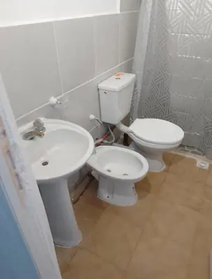 a bathroom with a white toilet and a sink at Monoambiente Cerro de las Rosas in Cordoba