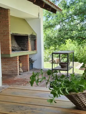 a porch of a house with an outdoor fireplace at Casa en Nono a 200 metros del lago in Las Rabonas