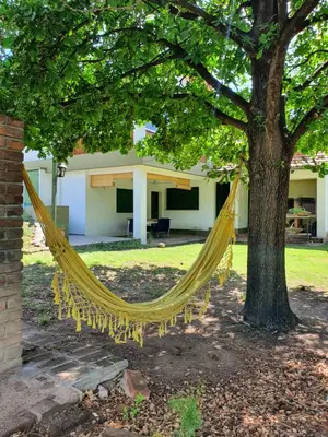 a hammock hanging from a tree in a yard at Casa en Nono a 200 metros del lago in Las Rabonas