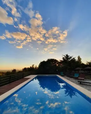 a large blue swimming pool with a cloudy sky at Hostería Vegetariana in Country Club Chumamaya