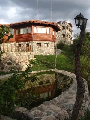 a house with a pond in front of it at Hostería Vegetariana in Country Club Chumamaya