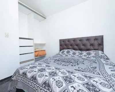 a bedroom with a bed with a black and white quilt at Casa entera in Mina Clavero