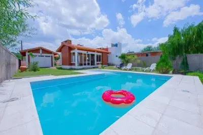 a swimming pool with a red float in front of a house at Casa entera in Mina Clavero