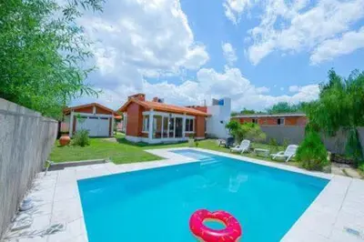 a swimming pool with a red frisbee in front of a house at Casa entera in Mina Clavero