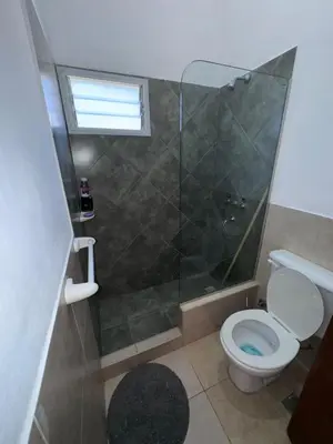 a bathroom with a toilet and a glass shower at Dúplex Juncal in Villa Carlos Paz
