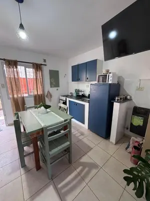 a kitchen with a table and a blue refrigerator at Dúplex Juncal in Villa Carlos Paz