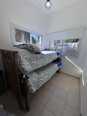 a small bedroom with a bed and a window at Dúplex Juncal in Villa Carlos Paz