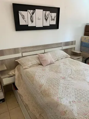 a bedroom with a bed with a wooden headboard at El Paraiso in Villa Carlos Paz