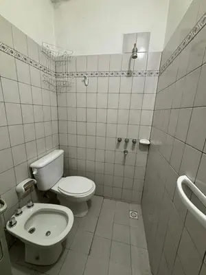 a white bathroom with a toilet and a sink at Alojamiento en Villa Cura Brochero in Villa Cura Brochero