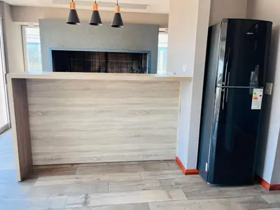 a kitchen with a black refrigerator and a fireplace at Depto con hermosas vistas, centro con solarium y seguridad in Cordoba
