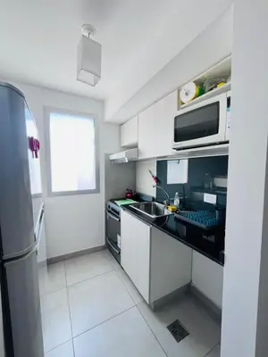a kitchen with a sink and a microwave at Depto con hermosas vistas, centro con solarium y seguridad in Cordoba