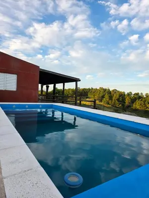 a swimming pool with blue water in front of a building at Munay Ky in Villa Ciudad de America