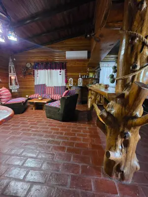 a living room with a table and a tree trunk at Munay Ky in Villa Ciudad de America