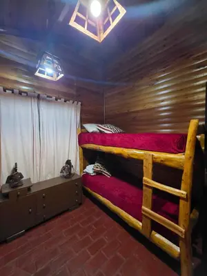 a bedroom with a bunk bed in a cabin at Munay Ky in Villa Ciudad de America