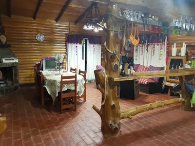 a dining room with a table and a table and a tree stump at Munay Ky in Villa Ciudad de America