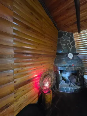 a room with a fireplace in a log cabin at Munay Ky in Villa Ciudad de America