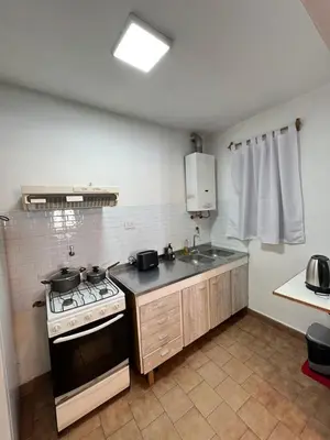 a kitchen with a stove and a sink at Duplex Único Frente al Río in Villa Carlos Paz