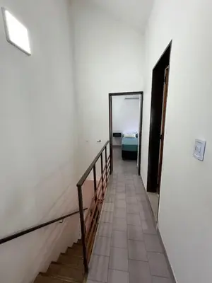 a hallway with a staircase and a room with a bed at Duplex Único Frente al Río in Villa Carlos Paz