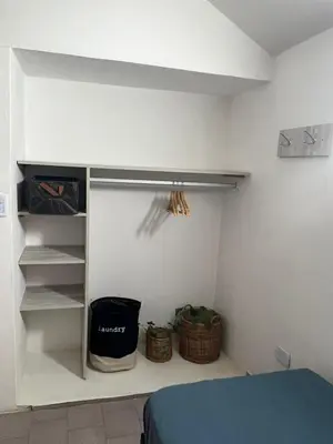 a bedroom with a bed and some baskets and shelves at Duplex Único Frente al Río in Villa Carlos Paz