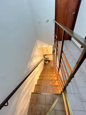 a staircase in a house with a wooden railing at Duplex Único Frente al Río in Villa Carlos Paz