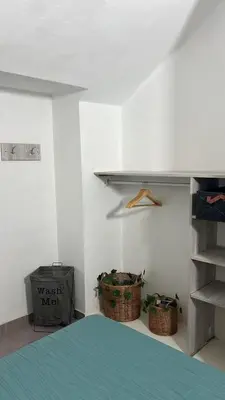 a bedroom with two baskets and a shelf and a bed at Duplex Único Frente al Río in Villa Carlos Paz