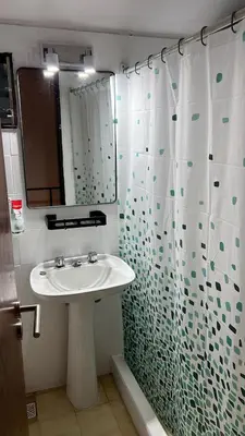 a bathroom with a sink and a shower curtain at Duplex Único Frente al Río in Villa Carlos Paz