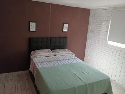 a bedroom with a bed with a green blanket at Virdi ca fui in Cordoba