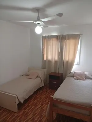 a bedroom with two beds and a ceiling fan at Hermosa casa a 15 min de Villa Carlos Paz in Villa Santa Cruz del Lago