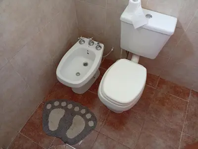 a bathroom with a toilet and a bidet at Hermosa casa a 15 min de Villa Carlos Paz in Villa Santa Cruz del Lago