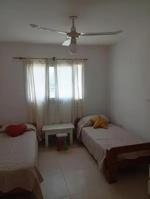 a bedroom with two beds and a ceiling fan at Hermosa casa a 15 min de Villa Carlos Paz in Villa Santa Cruz del Lago