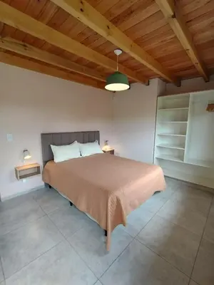 a bedroom with a bed and a wooden ceiling at Las Calandrias II in Los Reartes