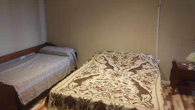 a small bedroom with a bed and a table at Las Lomitas 2 in Villa Cura Brochero
