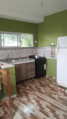 a kitchen with green walls and a sink and a refrigerator at Las Lomitas 2 in Villa Cura Brochero
