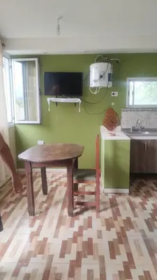 a kitchen with a wooden table and a sink at Las Lomitas 2 in Villa Cura Brochero