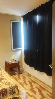 a bedroom with a black curtain and a table at Las Lomitas 2 in Villa Cura Brochero